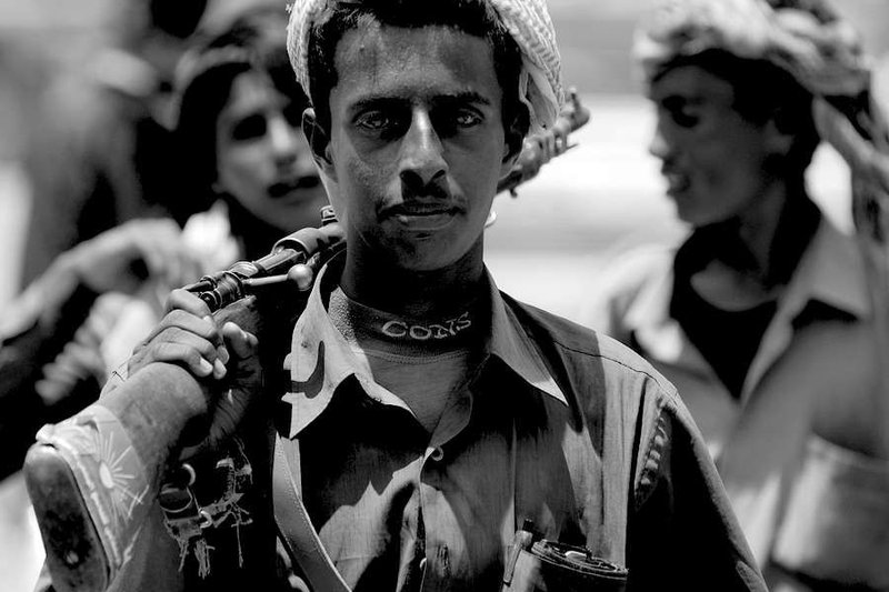 Unidentified young Yemeni man holds a rifle in Aden