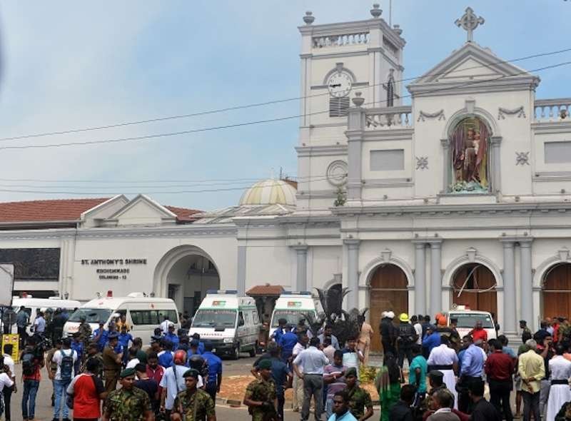 Ambulances are seen outside the church premises with gathered people and security personnel following a blast at the St. Anthony's Shrine in Kochchikade