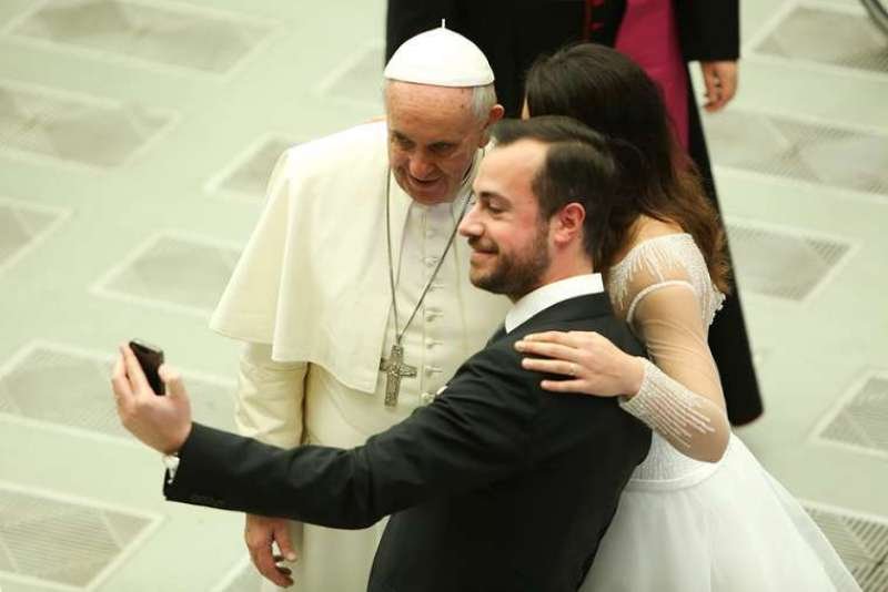 A newly married couple snaps a selfie with Pope Francis at the Wednesday general audience on Feb. 4