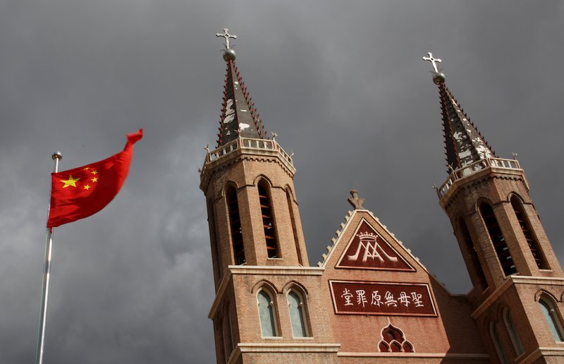 The Chinese national flag flies in front of a Catholic church in the village of Huangtugang