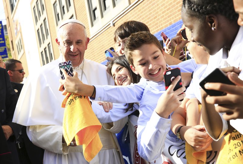 Students take "selfie" pictures with Pope Francis outside Our Lady Queen of Angels School in the East Harlem area of New York. rnCNS PHOTO/ERIC THAYER
