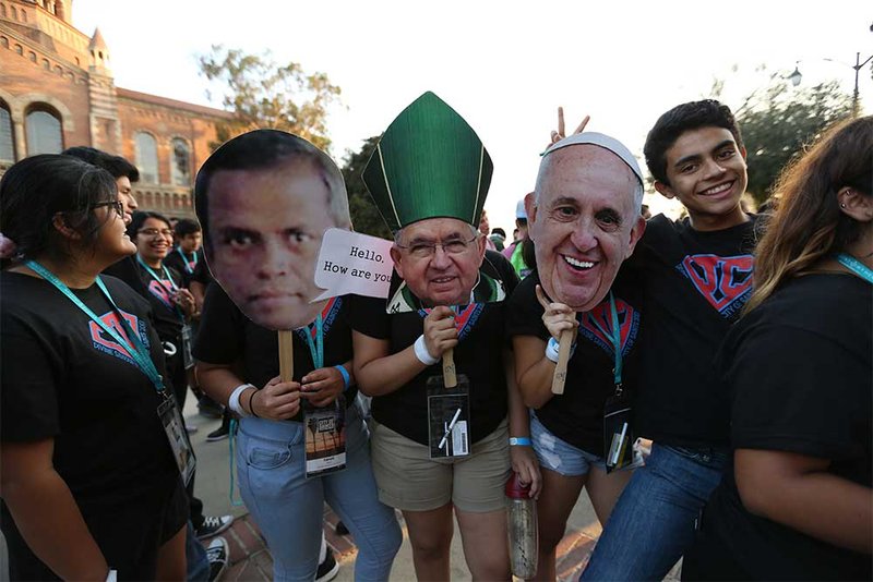 Youth from last year's City of Saints conference "pose" with the faces of Archbishop Gomez and Pope Francis.