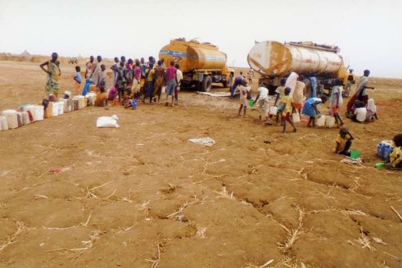 South Sudanese refugees queue to receive water at a refugee camp near Kosti