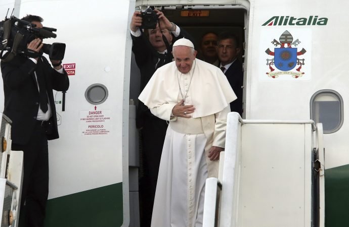 Pope Francis bows as he boards an airplane back to Rome