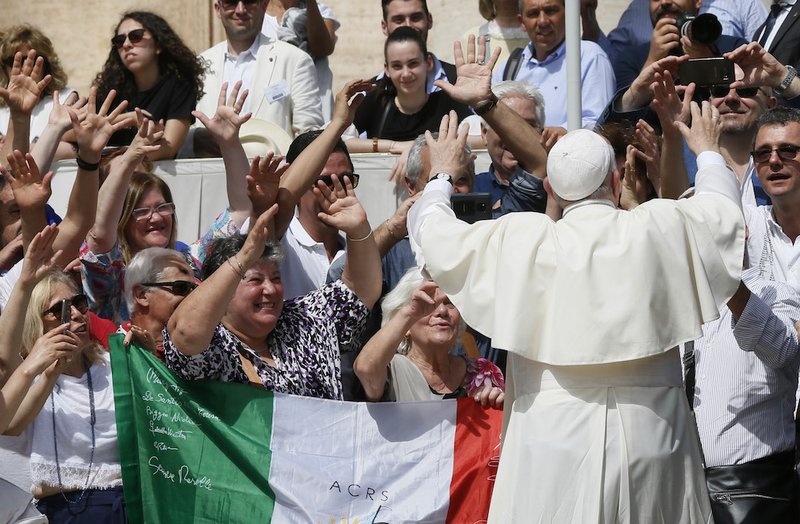 Pope Francis uses sign language in response to a group of people using sign language during his general audience in St. Peter's Square at the Vatican June 12