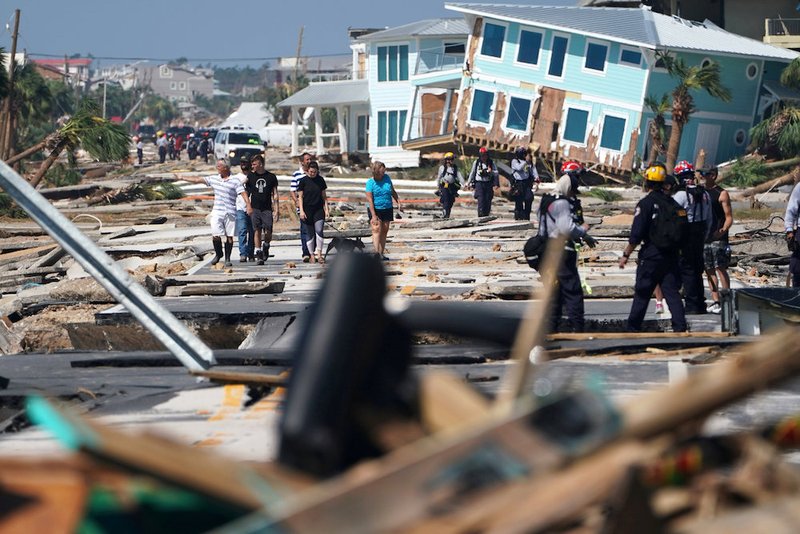 First responders and residents walk amid debris and destroyed homes Oct. 11 after Hurricane Michael swept through Mexico Beach