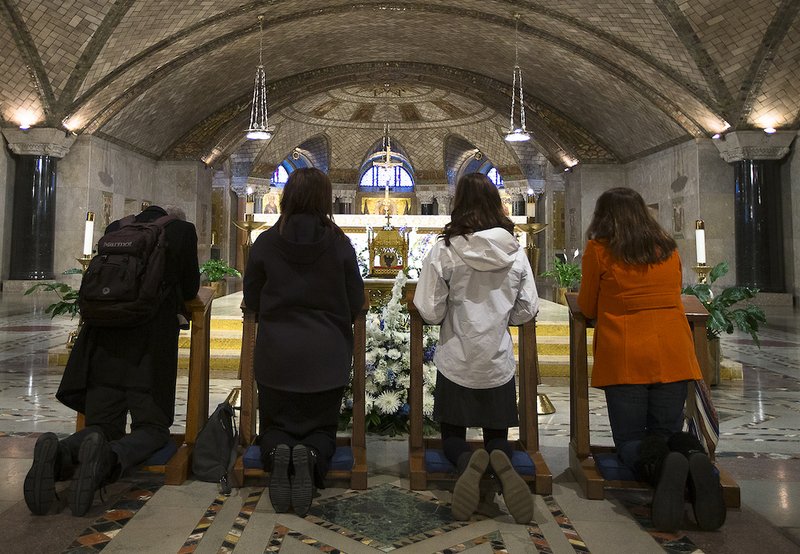 Worshippers venerate a reliquary containing St. John Vianney's incorrupt heart Dec. 10 in the Crypt Church at the Basilica of the National Shrine of the Immaculate Conception in Washington. (CNS PHOTO/TYLER ORSBURN)