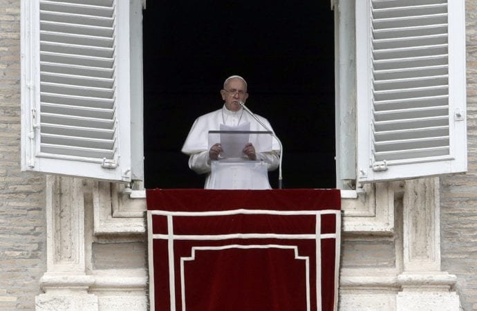 Pope Francis delivers his message during the Angelus noon prayer from the window of his studio overlooking St. Peter's Square