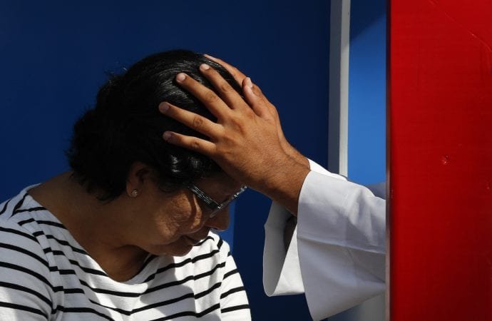 A Catholic priest administers the sacrament of confession at outdoor confessionals in Omar Park in Panama City