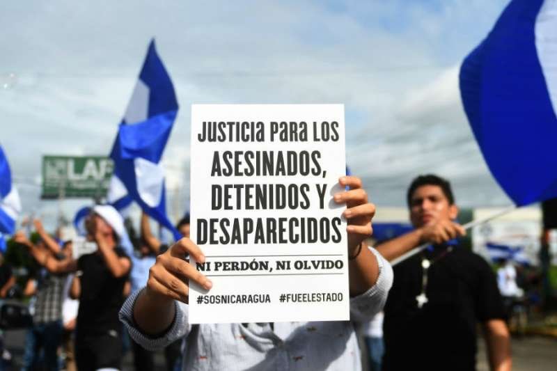 An anti-government demonstrator holds a sign in Managua