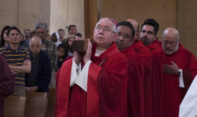 Archbishop Gomez carries a cross into the cathedral on Good Friday in 2018. VICTOR ALEMÁN