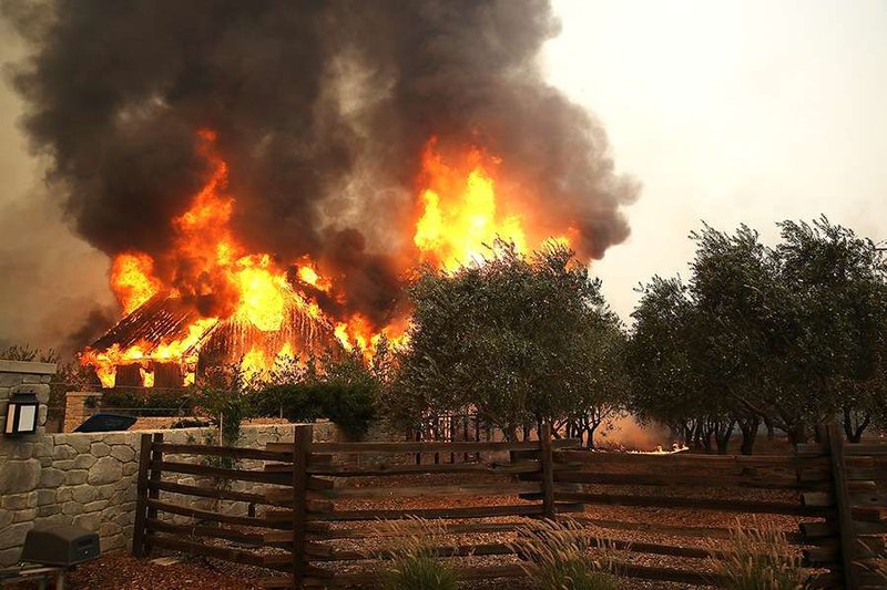 Fire consumes a barn as an out of control wildfire moves through the area in Glen Ellen