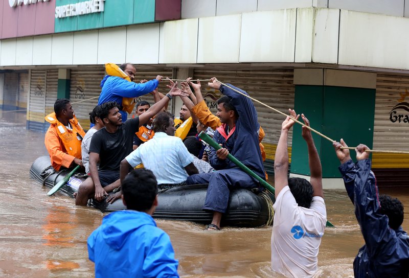 Rescue workers evacuate people from flooded areas Aug. 16 after the opening of a dam following heavy rains on the outskirts of Cochin