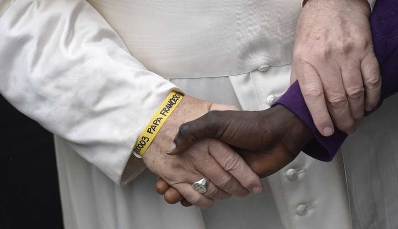 Pope Francis greets a migrant at a welcoming hub near Cesena