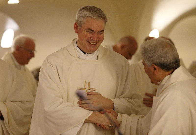 Auxiliary Bishop Richard Umbers of Sydney and other Australian bishops exchange the sign of peace as they concelebrate Mass in the crypt of St. Peter's Basilica at the Vatican June 24