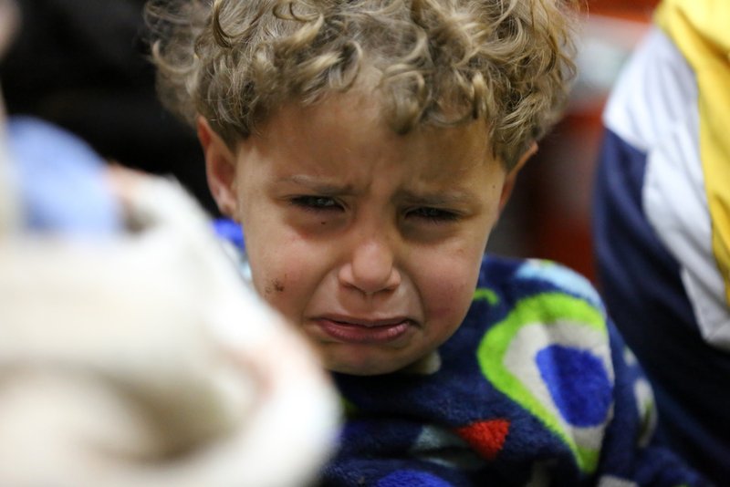 A Syrian child evacuated from Douma reacts upon arrival April 11 in Aleppo