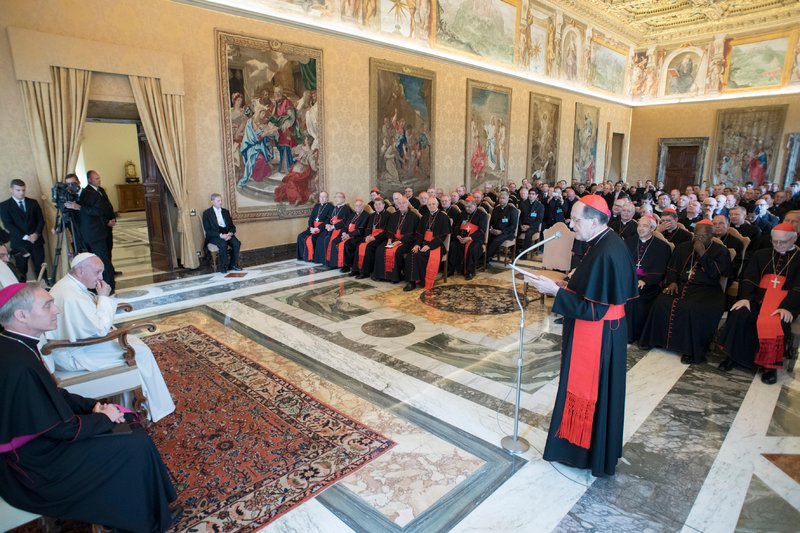 Pope Francis listens as Cardinal Beniamino Stella