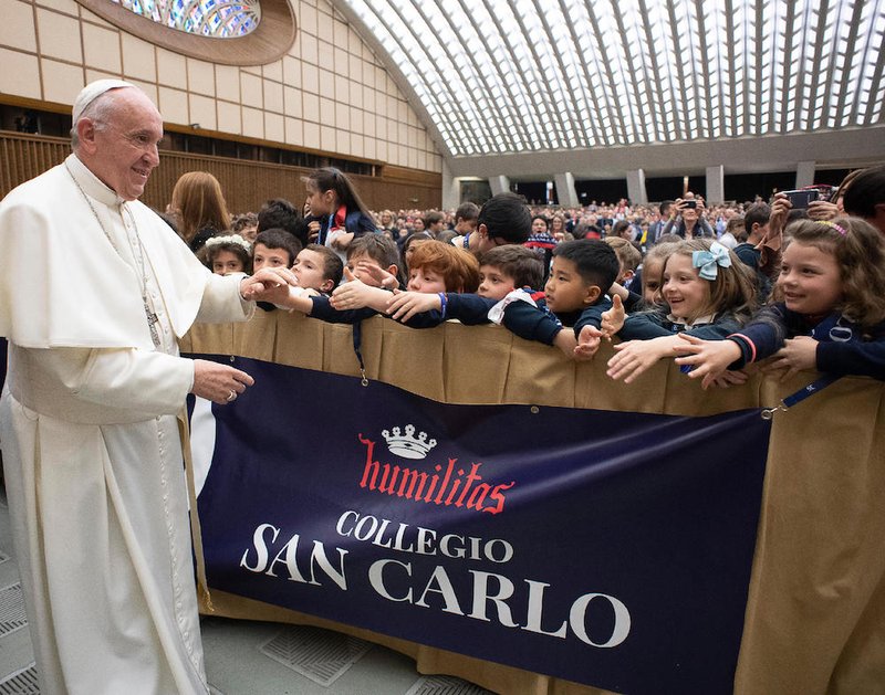 Pope Francis greets students from Milan's Istituto San Carlo during an audience at the Vatican April 6