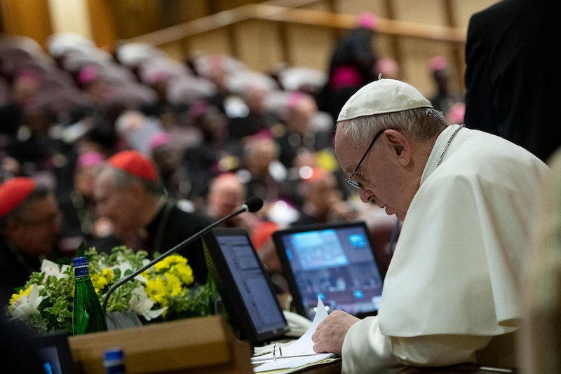 Pope Francis reviews papers during the third-day of a meeting on the protection of minors in the church at the Vatican Feb. 23