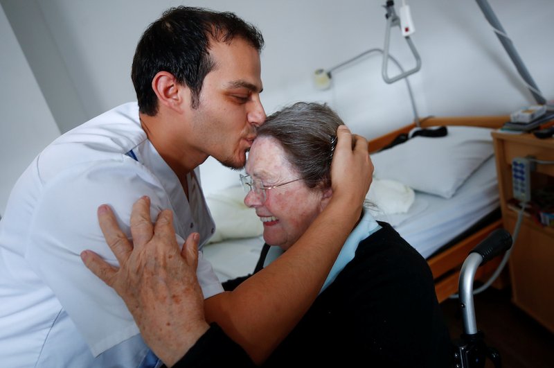 A woman in a Duesseldorf, Germany, receives a kiss from a retirement home employee Sept. 12, 2018. People cannot feel authentic compassion for others if they do not feel true love for Christ, Pope Francis said Feb. 1 during an audience with members of the Hospitaller Brothers of St. John of God. (CNS photo/Wolfgang Rattay, Reuters)