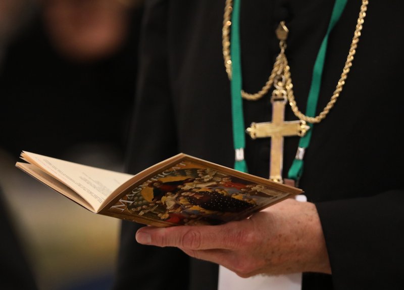 A bishop prays on the first day of the annual general assembly of the USCCB in Baltimore June 11
