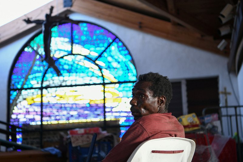 A man sits inside a damaged church serving as a shelter in Marsh Harbour