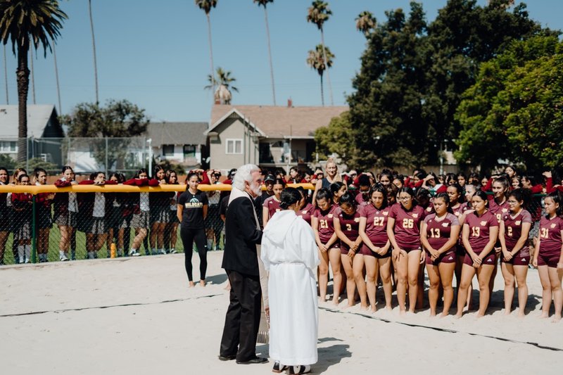 Fr. Alexei Smith blesses the new "Kerri Court" at Bishop Conaty - Our Lady of Loretto High School in the presence of students and volleyball star Kerri Walsh Jennings Aug. 20. (BISHOP CONATY - OUR LADY OF LORETTO HIGH SCHOOL)