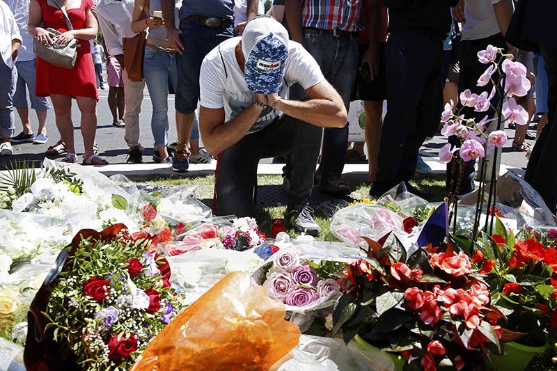 A man prays in front of a makeshift memorial July 15 in Nice