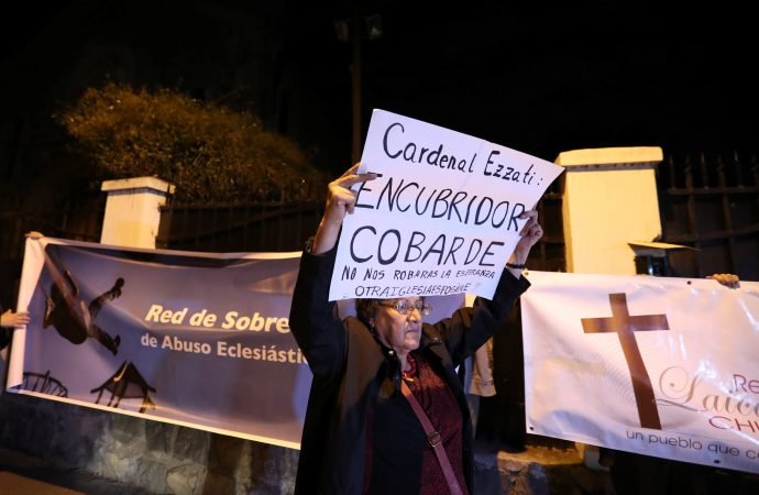 A demonstrator displays a banner during a rally against Chilean Cardinal Ricardo Ezzati over allegations he covered up sexual abuse of minors outside his residence in Santiago. The banner reads: "Cardinal Ezzati: Coward covering up! They will not steal our hope. Another church is possible" and "Survivors Network of Ecclesiastical Abuse." (CNS photo/Ivan Alvarado