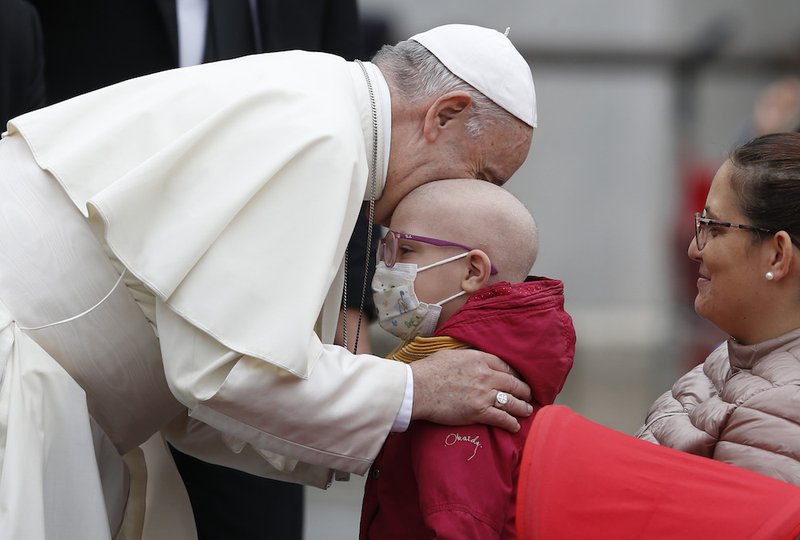 Pope Francis embraces a sick boy during his general audience in St. Peter's Square at the Vatican Oct. 17. (CNS photo/Paul Haring)