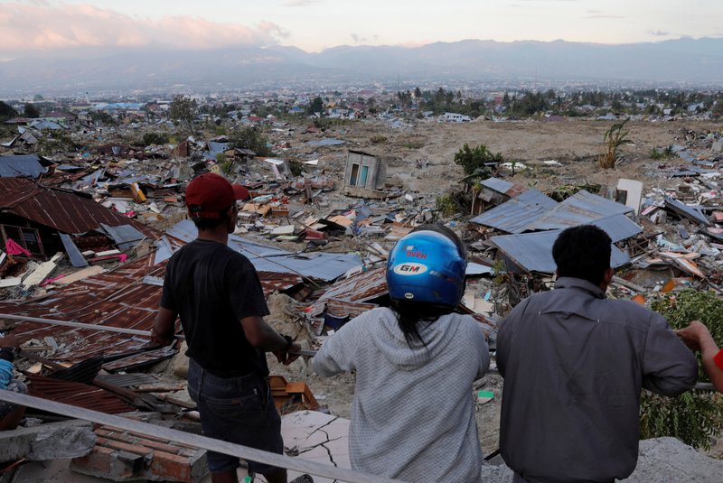 People look over debris Oct. 1 after an earthquake and tsunami on Indonesia's Sulawesi Island. (CNS photo/Beawiharta