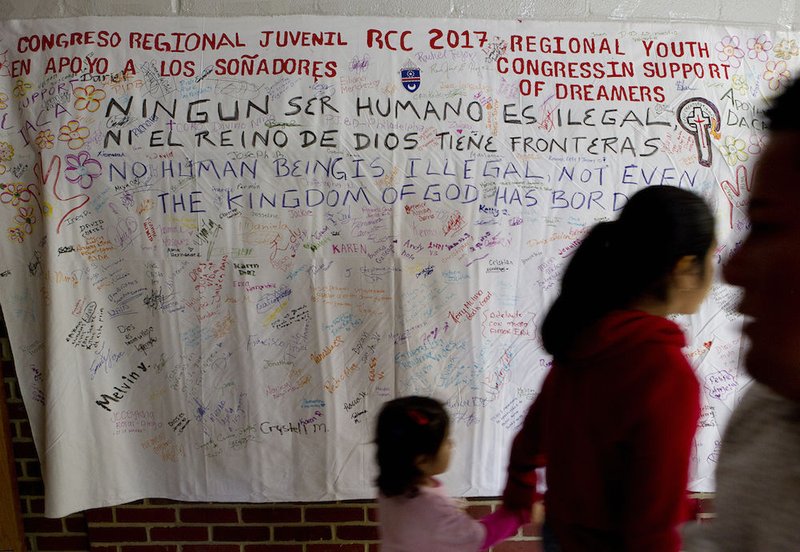 People walk in front of a banner supporting "Dreamers" during a daylong regional encuentro Oct. 28 at Herndon Middle School in Herndon