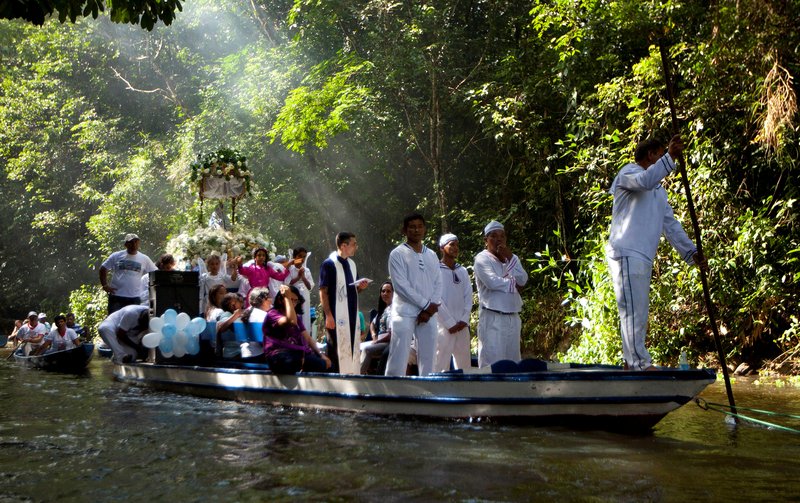 A priest holds a Bible as he leads pilgrims in prayer during an annual river procession and pilgrimage on the Caraparu River in Santa Izabel do Para, Brazil, in this 2012 file photo. (Paulo Santos/Catholic News Service, Reuters)