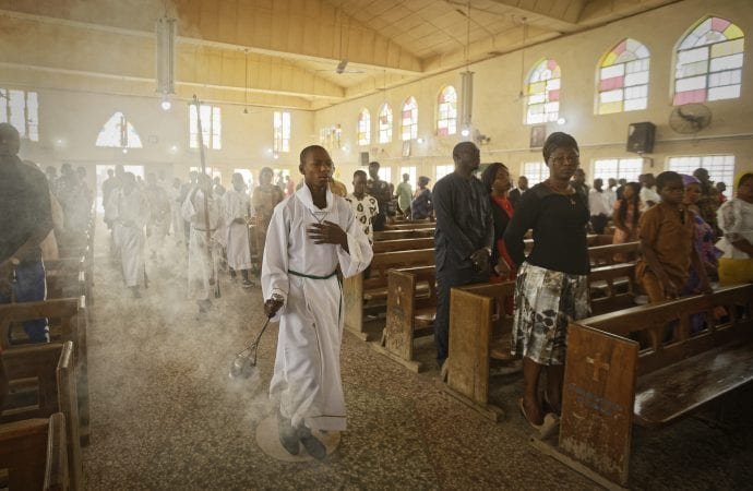 An altar boy swings the thurible of incense during a morning service at the Saint Charles Catholic Church
