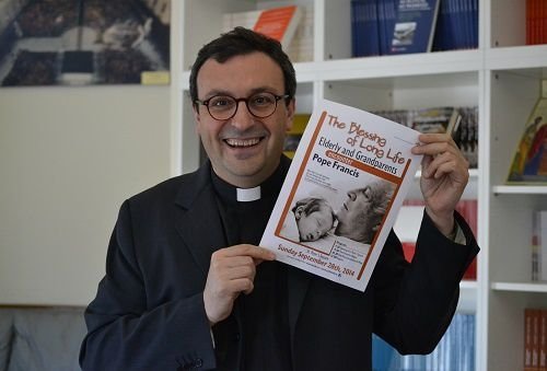 Fr. Andrea Ciucci holds a flyer for Pope Francis' Sept. 28 audience with elderly and grandparents. Credit: Daniel Iba√±ez/CNA.