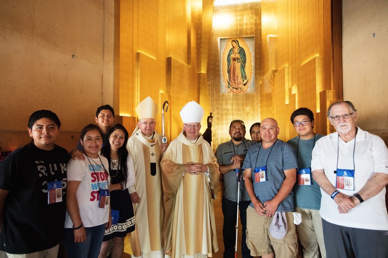 Archbishop José H. Gomez and Orange Bishop Kevin W. Vann pose for a photography with pilgrims who journeyed from Lake Forest