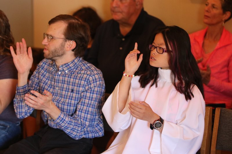 Christopher Sloan and Sophia Jo Peters sign the creed during a Mass in sign language in early September in the chapel at St. Peter Parish in Portland