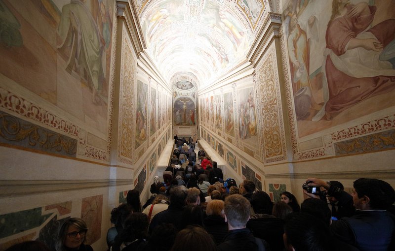A crowd waits as people climb the restored Holy Stairs during their unveiling at the Pontifical Sanctuary of the Holy Stairs in Rome April 11