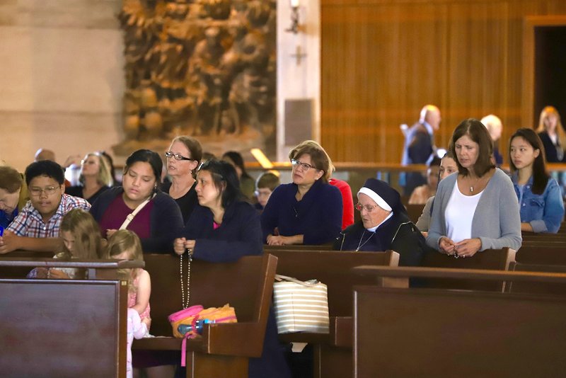 Worshippers pray the rosary at San Francisco's Cathedral of St. Mary of the Assumption before Mass Aug. 11