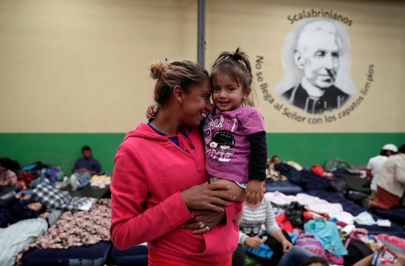 A Honduran migrant holds her daughter Oct. 18 at a Scalabrinian-run shelter in Guatemala City. She and the other migrants at the shelter are part of a caravan trying to reach the U.S. (CNS photo/Luis Echeverria