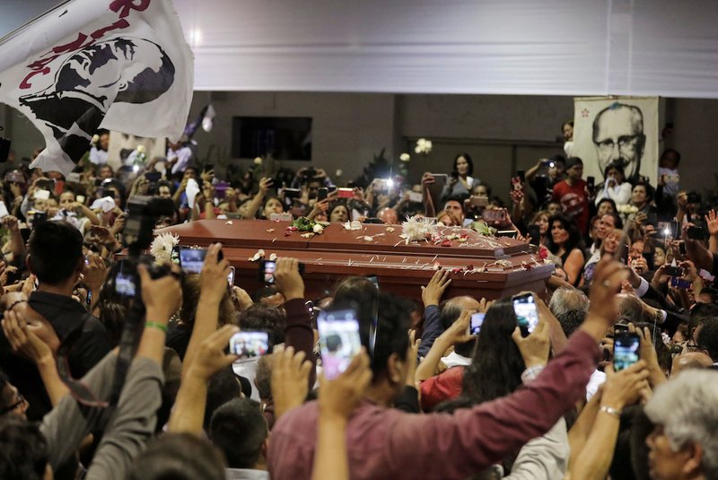 People react as the coffin holding the body of former Peruvian President Alan Garcia arrives at the APRA party headquarters April 18