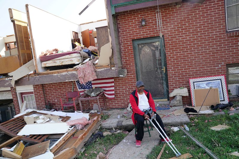 A man sits outside his destroyed home May 23
