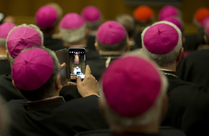 A bishop takes a photo of Pope Francis during the opening session of the CEI