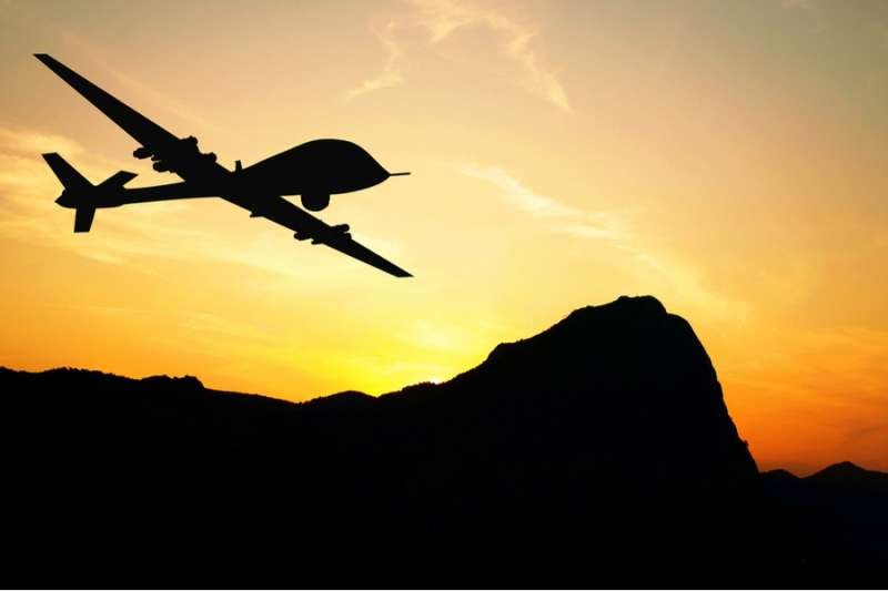 Drone flying over mountains on sunset background. Via Shutterstock