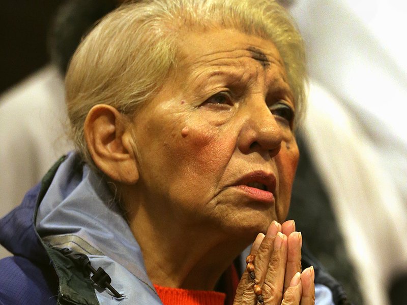 A woman prays during Ash Wednesday Mass in the chapel at the Franciscan Monastery of the Holy Land in Washington Feb. 14