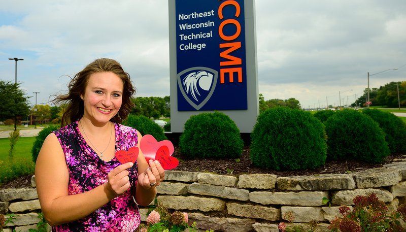 Polly Olsen holds three handmade Valentine cards that feature a Bible passage and messages such as "Jesus Loves You!" outside the Northeast Wisconsin Technical College Sept. 21, 2019, in Green Bay, Wis. Olsen was told that handing out the cards constituted "soliciting" and was in violation of the college's public assembly policy. She was also told that some people might find the Bible references on her cards offensive. (CNS photo/Sam Lucero, The Compass)