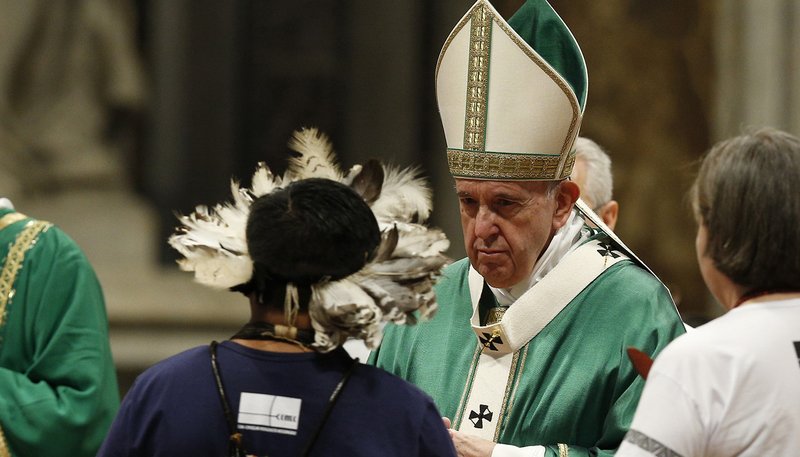 Pope Francis accepts offertory gifts as he celebrates the opening Mass of the Synod of Bishops for the Amazon in St. Peter's Basilica at the Vatican Oct. 6, 2019. (CNS photo/Paul Haring)