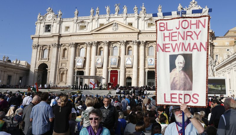 A man holds a banner showing new St. John Henry Newman before the canonization Mass for five new saints celebrated by Pope Francis in St. Peter's Square at the Vatican Oct. 13, 2019. (CNS photo/Paul Haring)