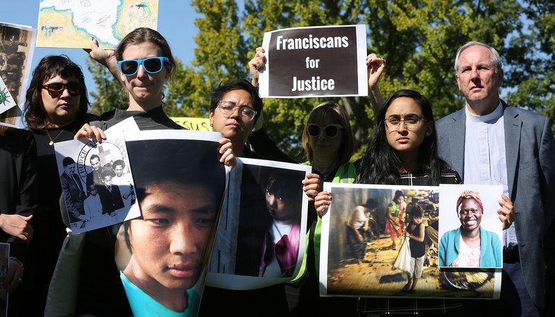 Activists hold signs during a protest Oct. 15, 2019, outside the U.S. Capitol in Washington against the Trump administration's cuts in the number of refugees to be admitted under the U.S. resettlement program. (CNS photo/Bob Roller)