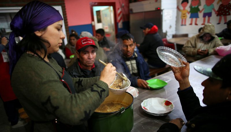 A volunteer serves a meal at a soup kitchen in Buenos Aires, Argentina, Oct. 4, 2019. Resolving the global crises of world hunger and malnutrition demands a shift away from a distorted approach to food and toward healthier lifestyles and just economic practices, Pope Francis said in an Oct. 16 message. (CNS photo/Agustin Marcarian, Reuters)